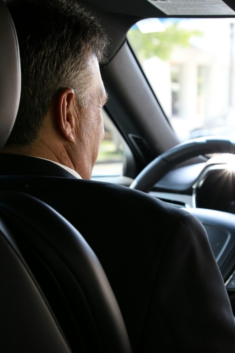 A HakuCab chauffeur assisting a business traveler with their luggage.